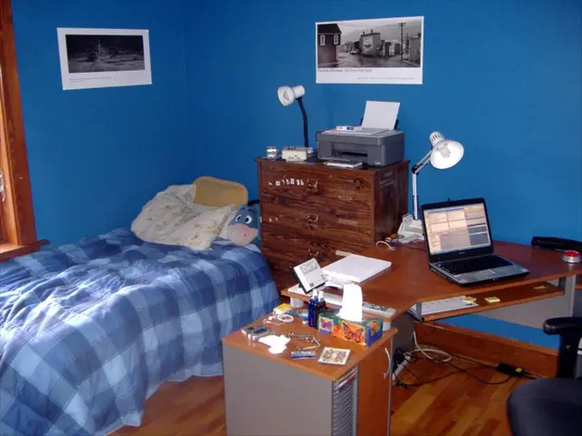 This picture is clicked inside the room. On the left bottom, we see a bed with blue color bed sheet...