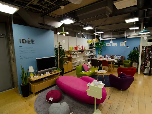 Home appliances and furniture are placed representing a home environment in a store. There is a TV...